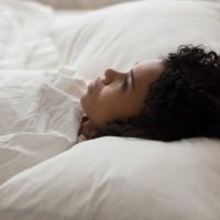 mujer triste tumbada en la cama
