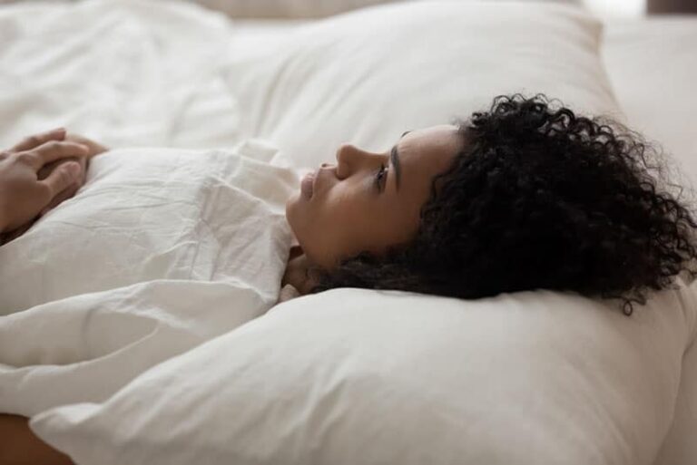 sad woman laying in bed