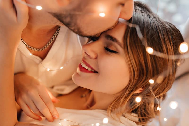 Un homme blanc embrassant sa petite amie sur le front. Portrait en gros plan d'un mari aimant exprimant sa tendresse à sa femme.