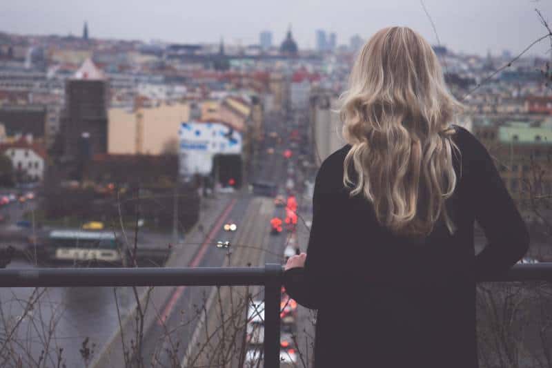 Woman looking at city from balcony