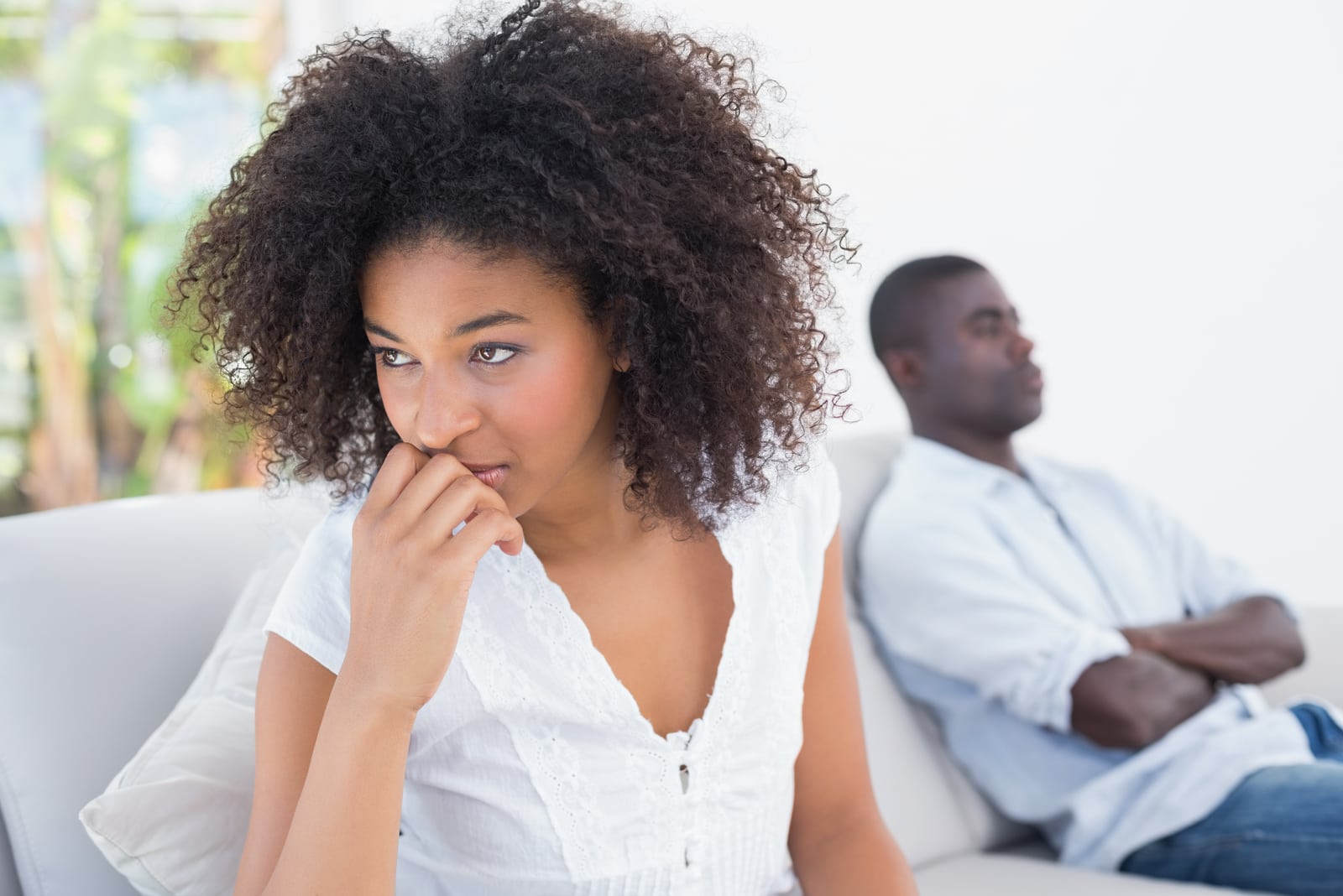 a loving couple with problems sitting on the couch after an argument