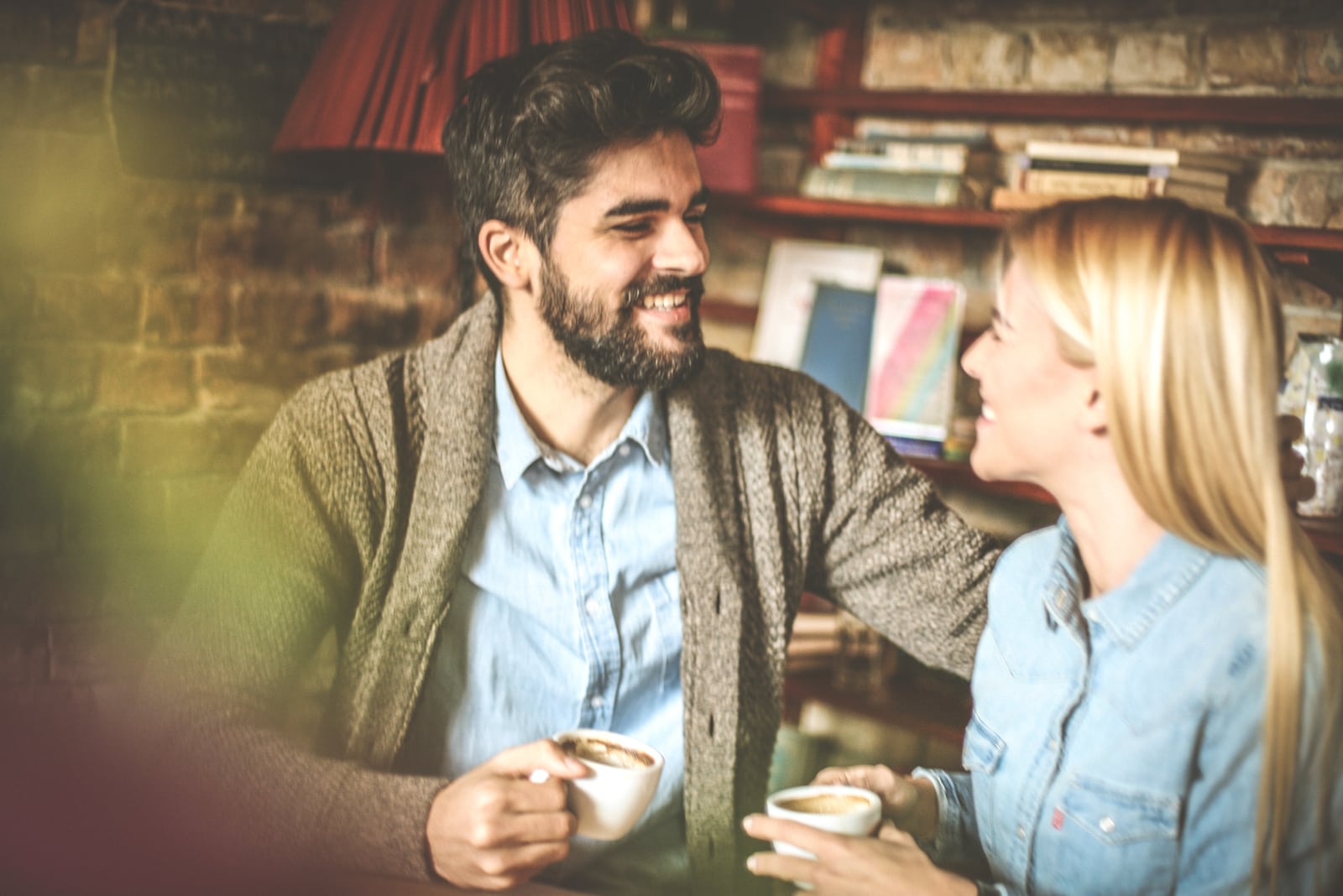 una pareja sonriente tomando café en una cafetería