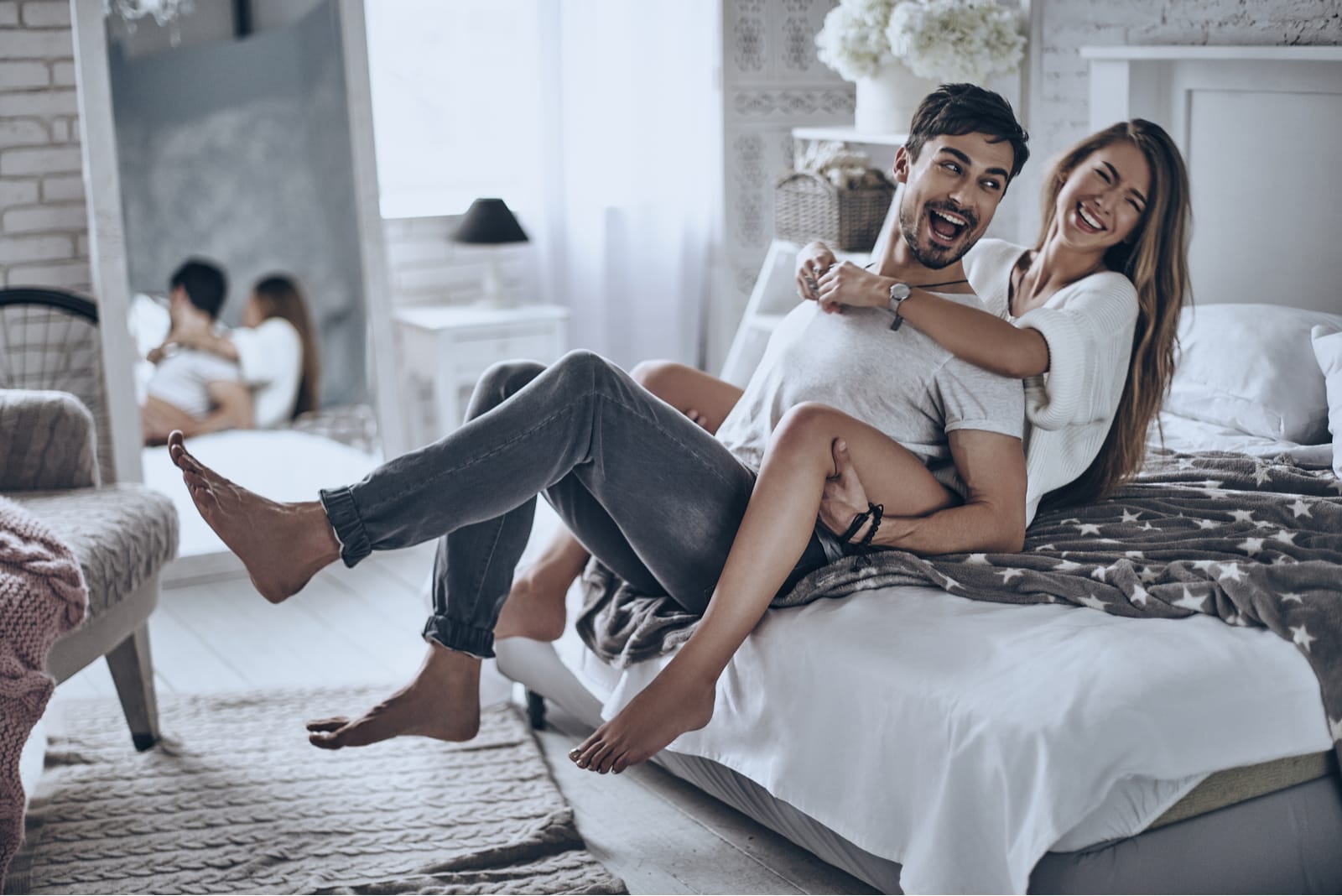 um casal sorridente e amoroso que se abraça e se diverte no quarto