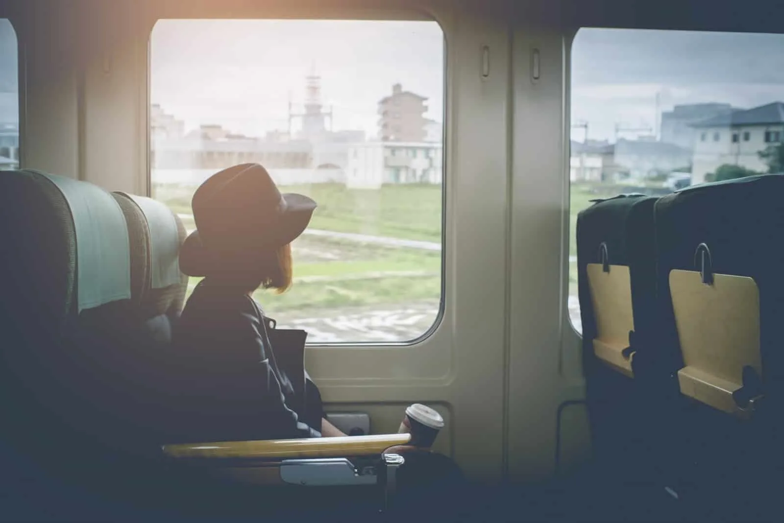 a woman with a hat travels by train