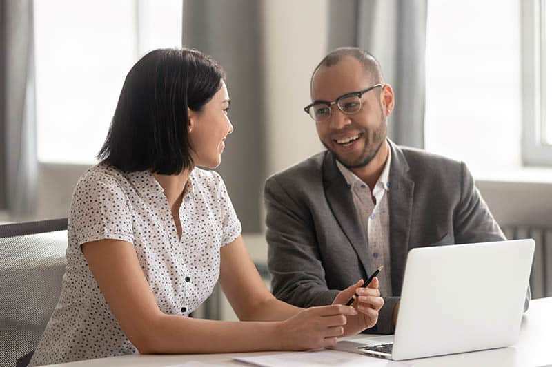 business male and female talking at office desk