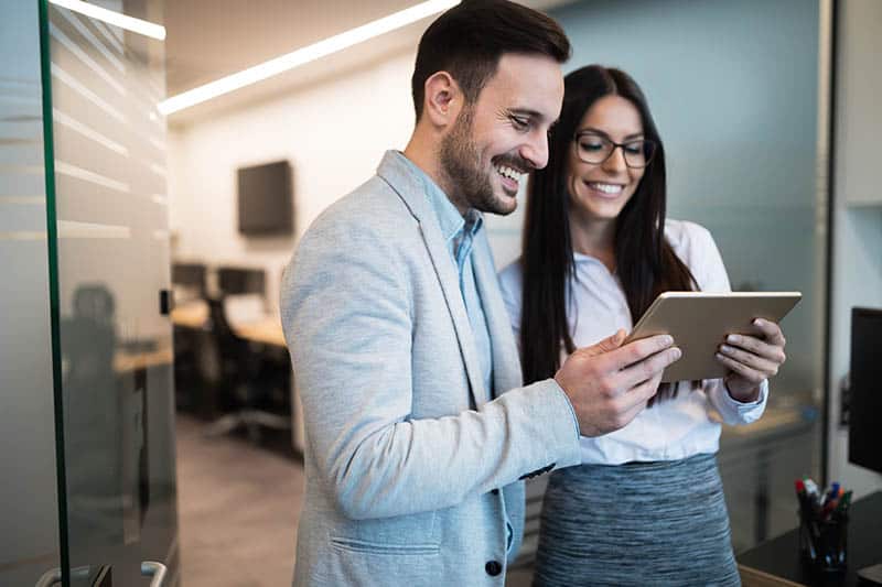 business man and woman looking at tablet