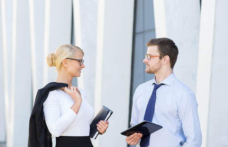 hombre y mujer de negocios hablando en el exterior