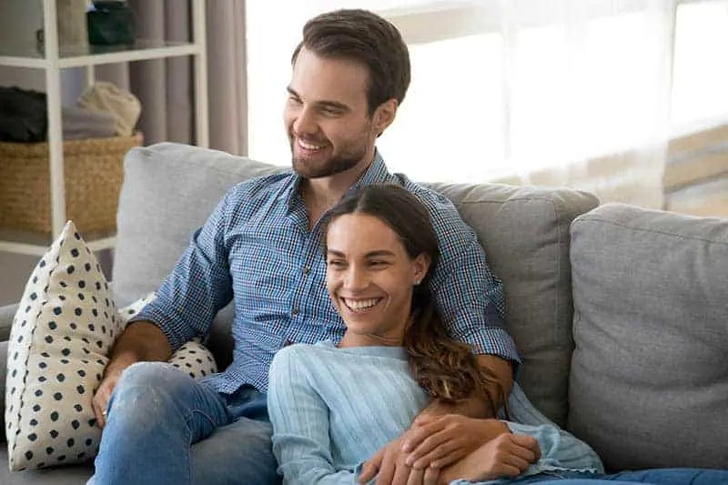 couple sitting on couch and watching Tv