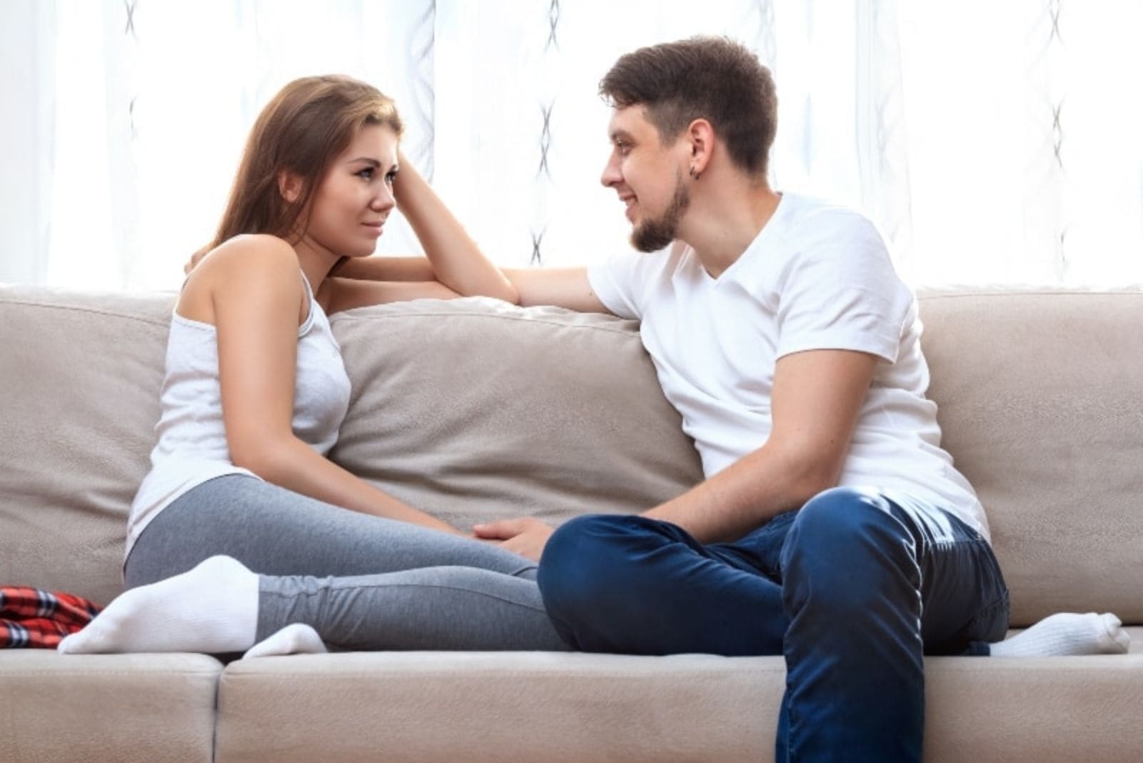 pareja hablando y sentada en el sofá de casa