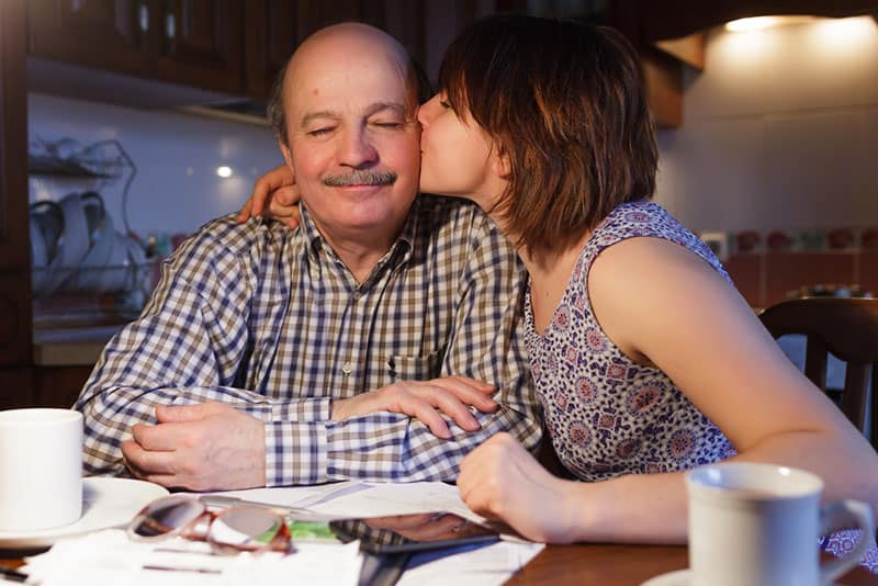 figlia che bacia il padre sulla guancia