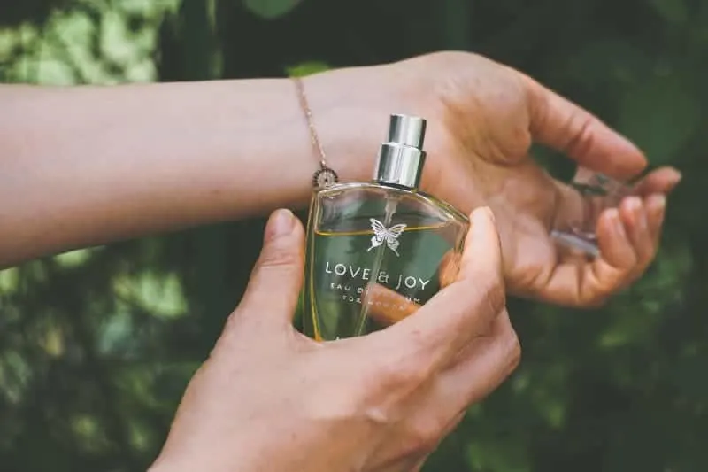 girl puts perfume on hand