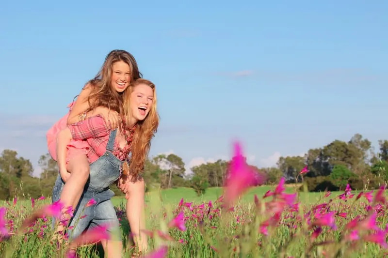 happy woman piggybacking her best friend