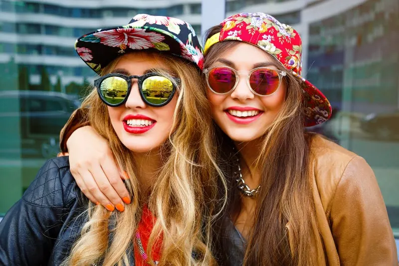 hipster female friends wearing cap and sunglasses