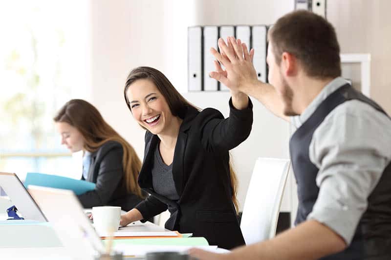 uomo e donna si danno il cinque in ufficio