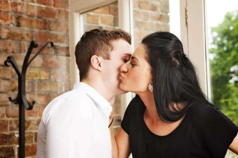 man and woman kissing on cheek