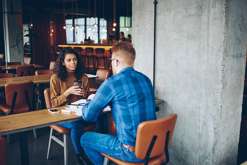 man and woman talking at cafe