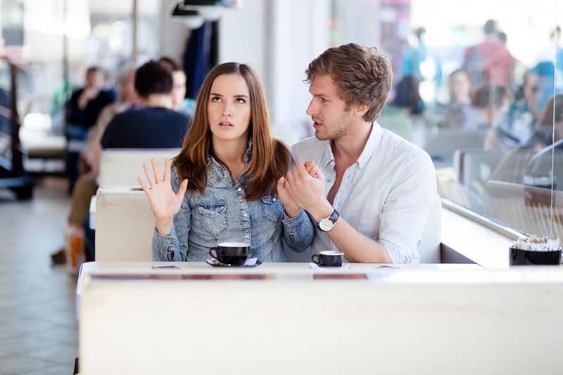 man apologizing to woman while she scrolls with eyes