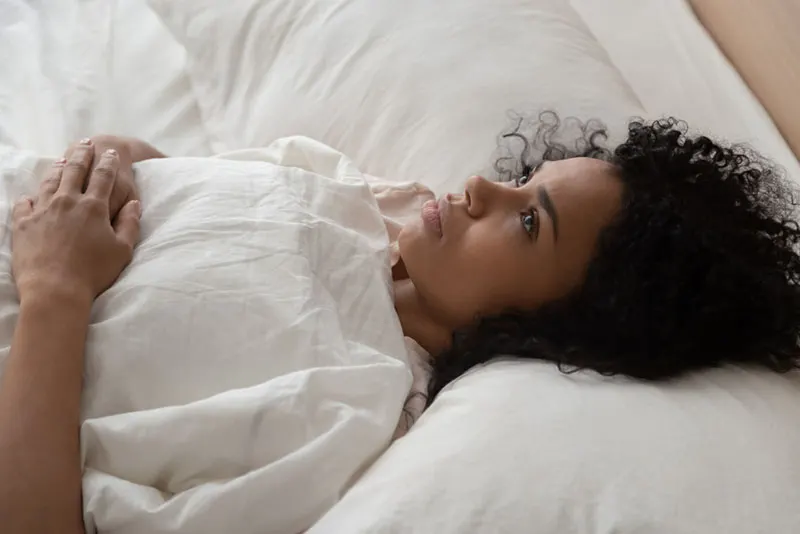 mindful woman lying in bed