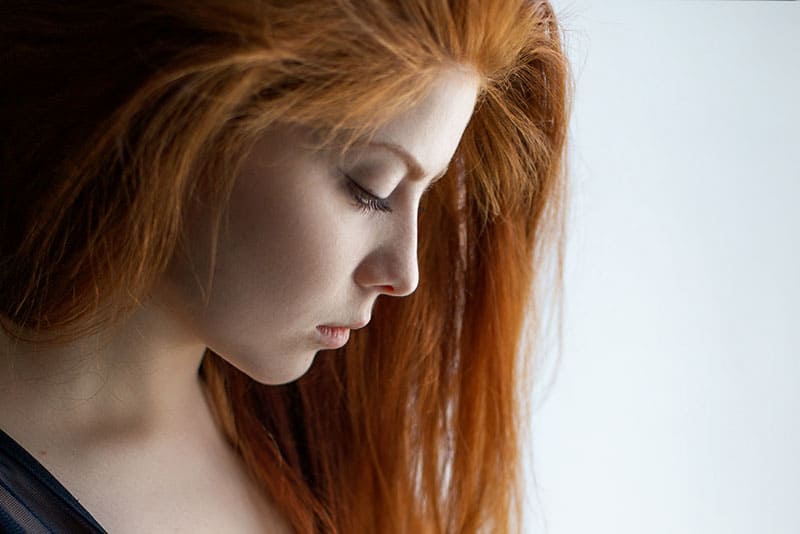 donna minuta con capelli rossi che guarda in basso