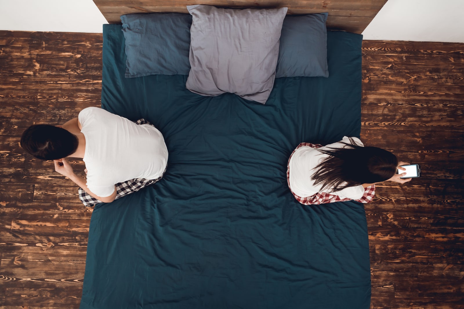 sad couple sitting in bedroom