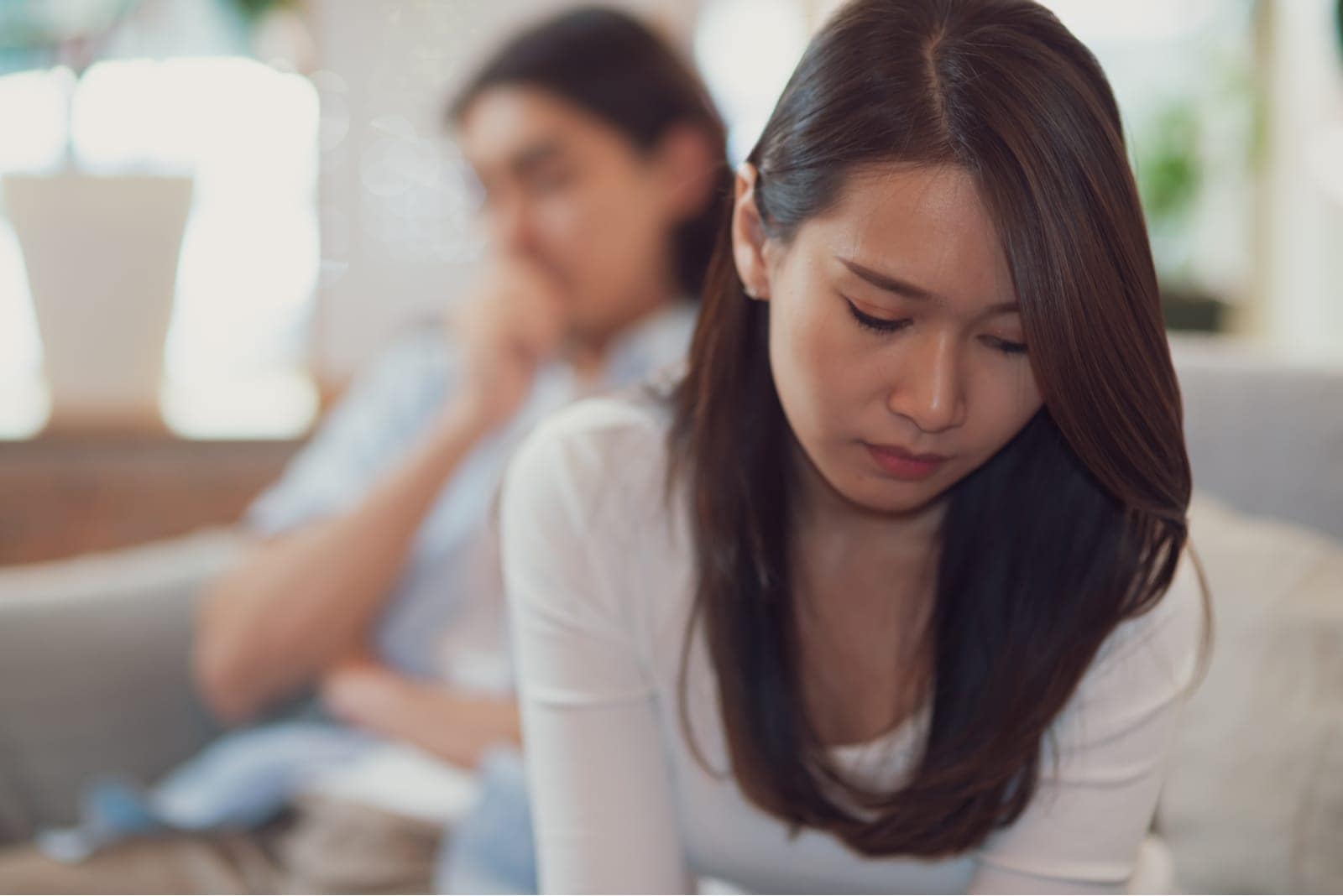 sad couple sitting on bed