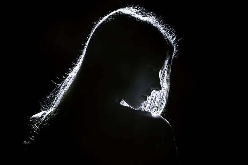 donna triste in piedi nel buio