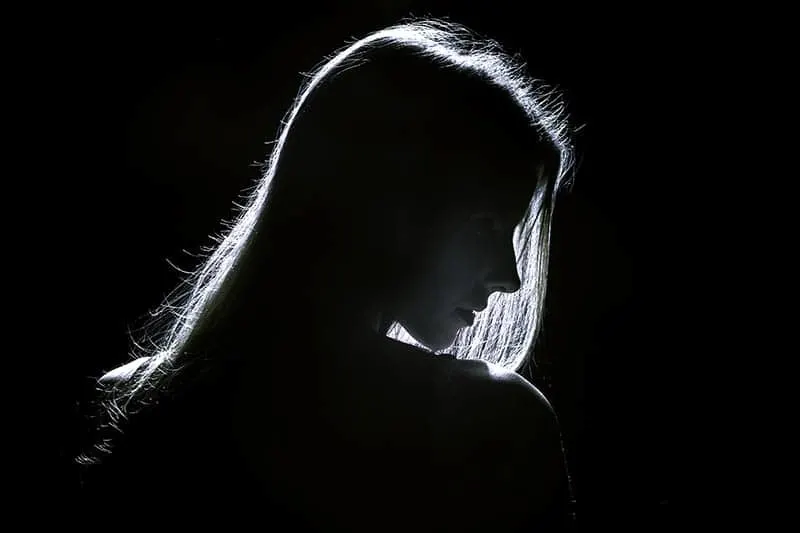 sad woman standing in the dark