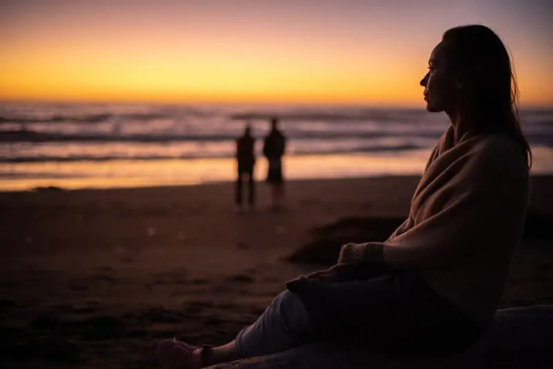 Woman enjoying sunset near ocean