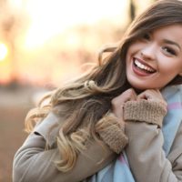 half length portrait of young happy woman walking in the street on sunset