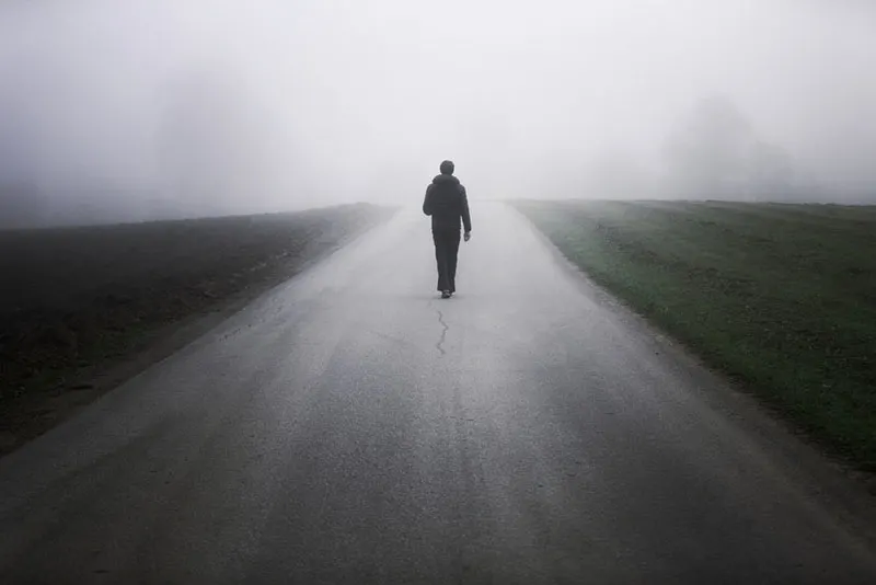 Man alone on foggy road