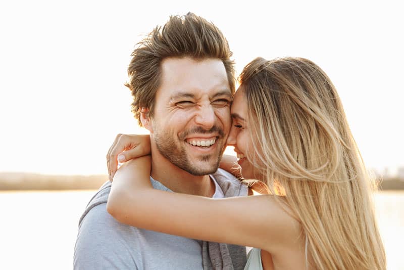 pareja sonriente abrazándose 