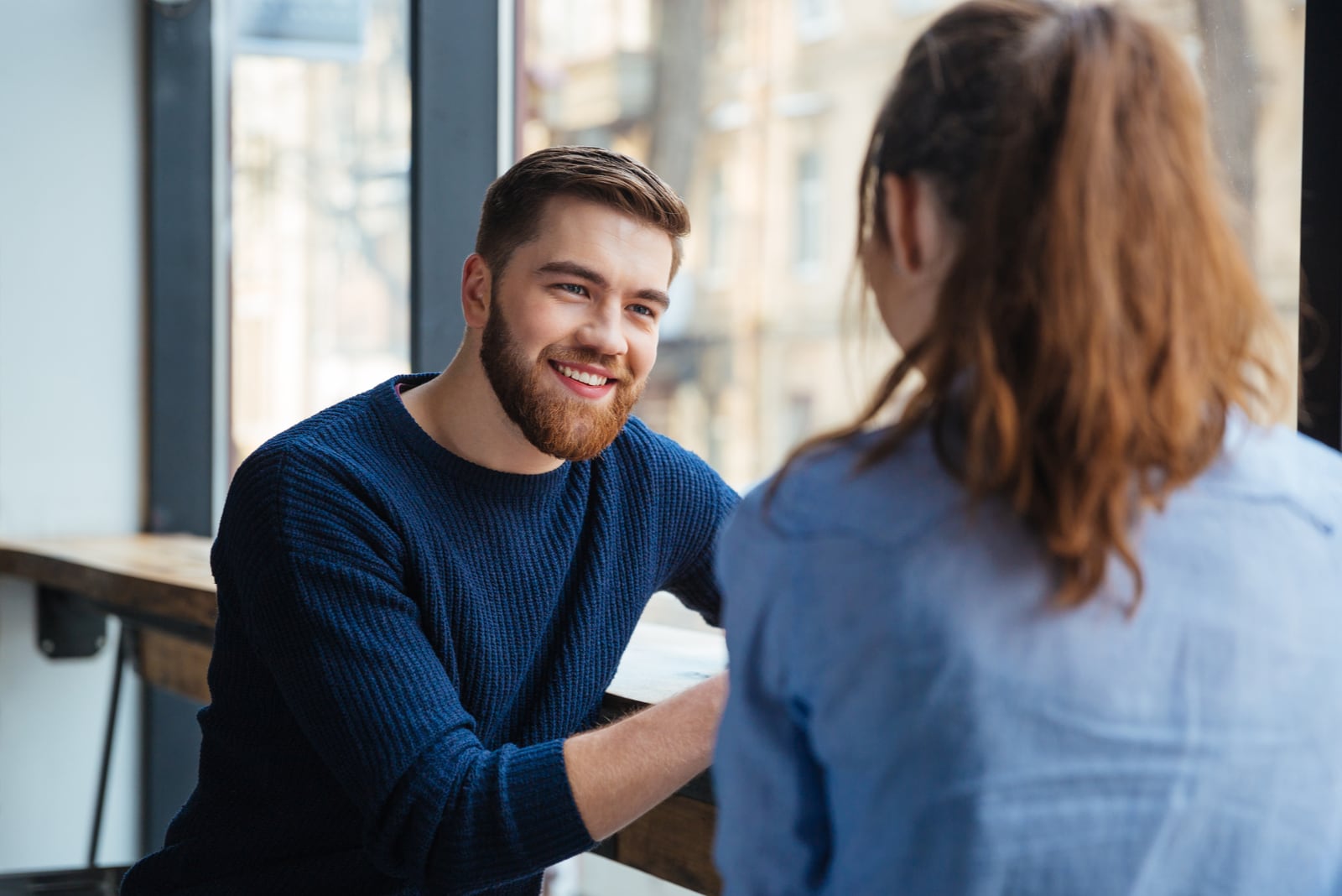 smiling man with beard looking at woman