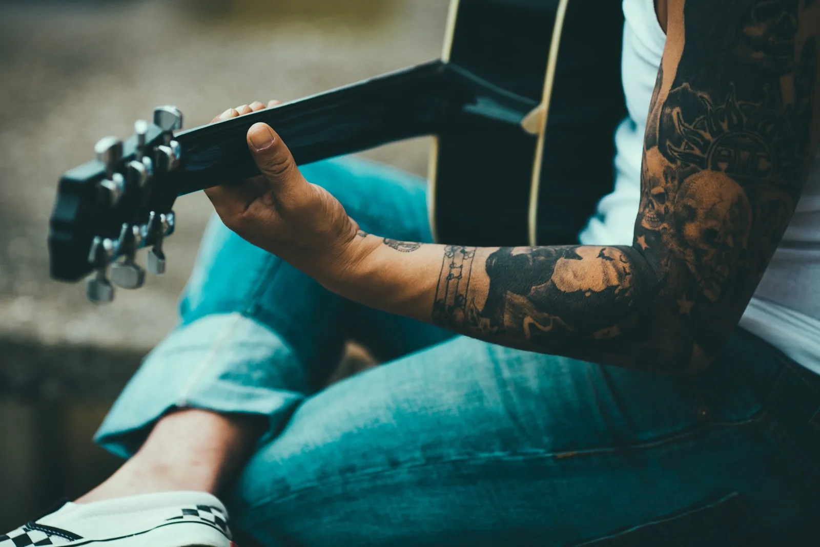 tattooed man playing guitar