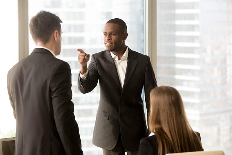 upset man pointing finger at another man in office