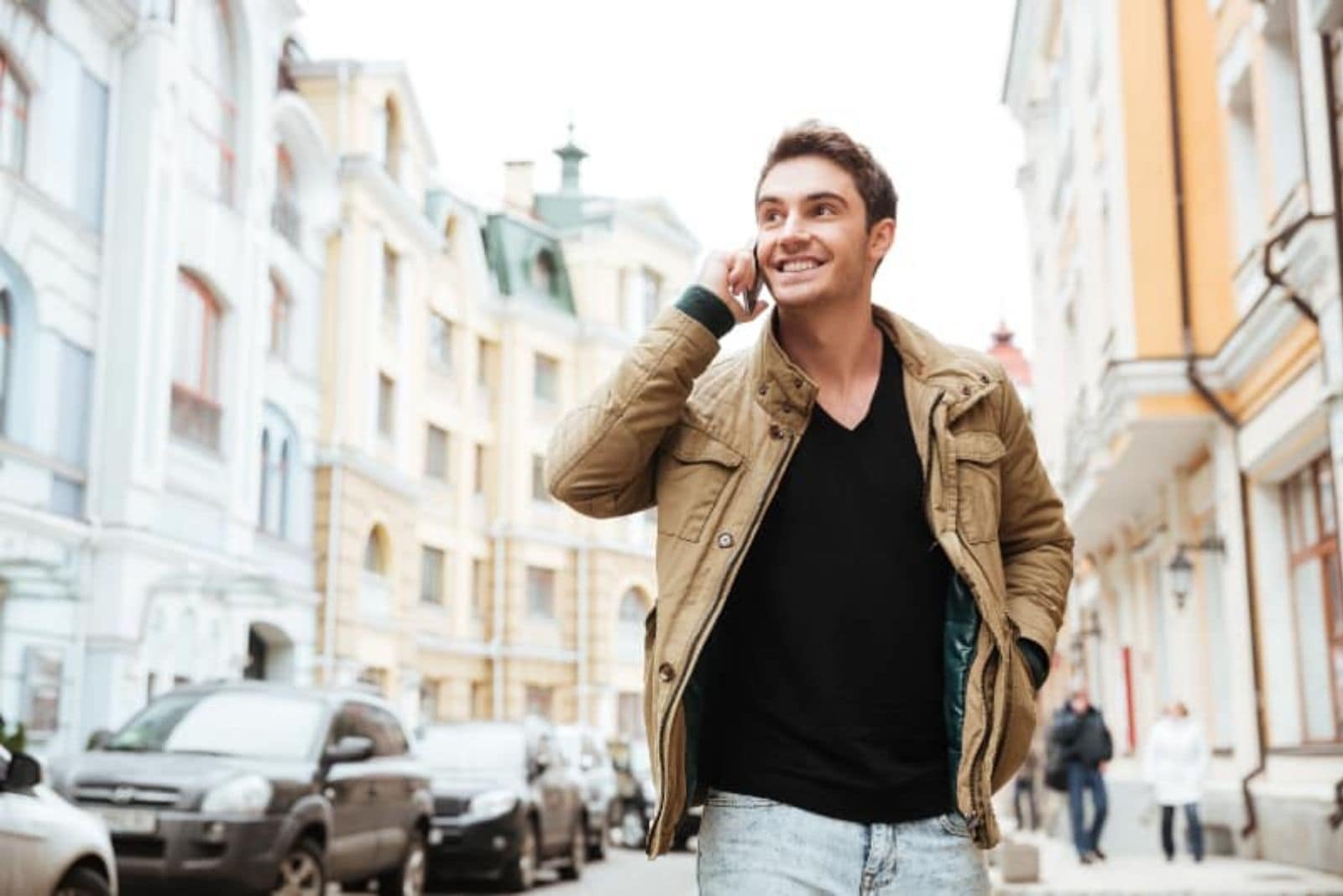 joven feliz caminando y hablando por teléfono