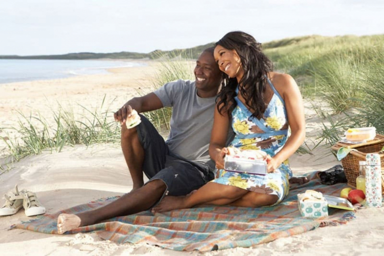 a man and a woman are sitting on the beach