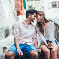 smiling couple sitting on concrete stairs