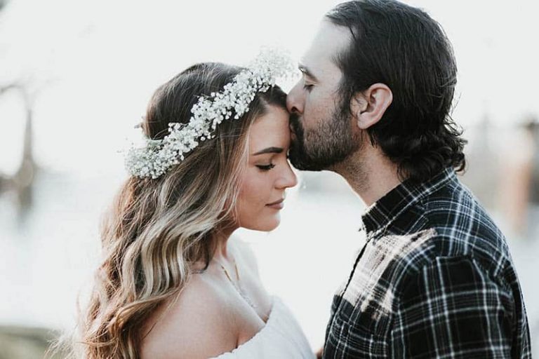 man kisses woman forehead