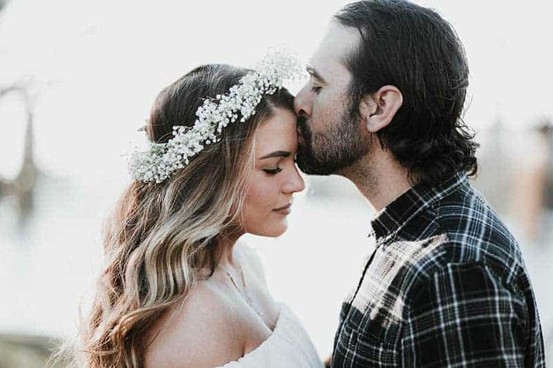man kisses woman forehead