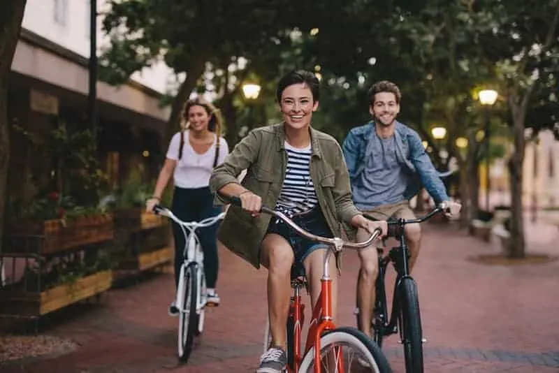 Male and female friends on road with their bikes