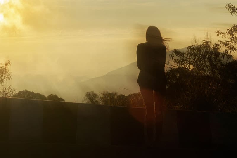 Silhouette woman standing alone amidst the fog