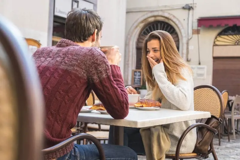 Surprised girl with man in street cafe