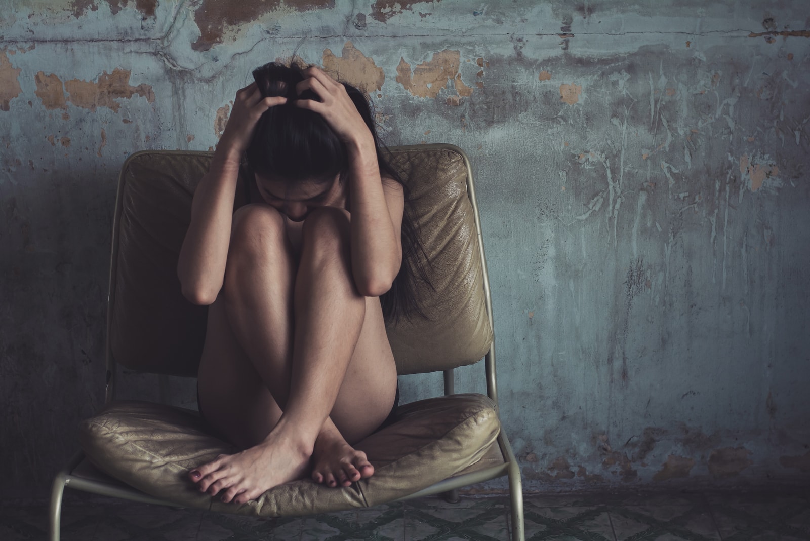 a depressed woman sitting in an armchair