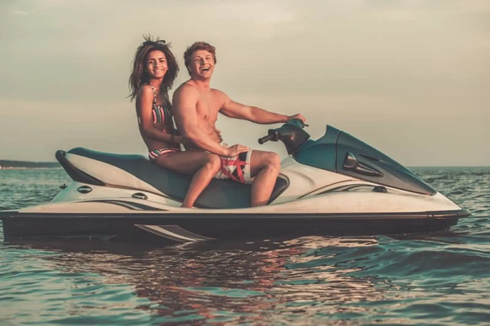a man and a woman ride on a speedboat