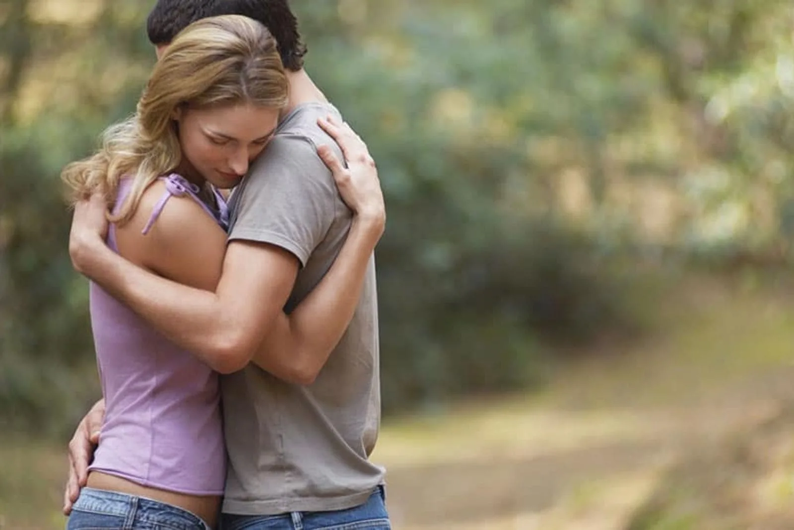 a man and a woman stand embracing