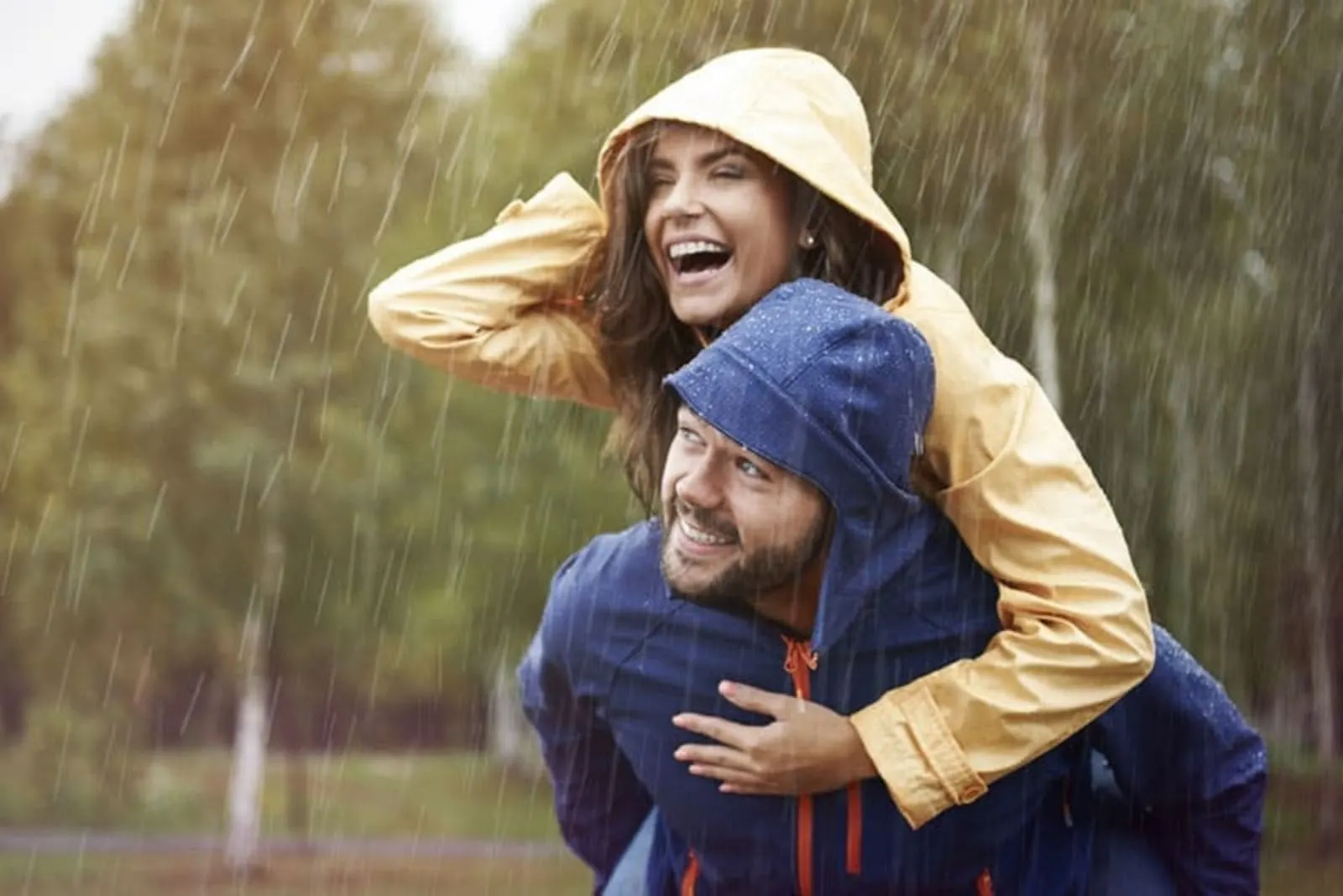 a man carries a woman in the rain