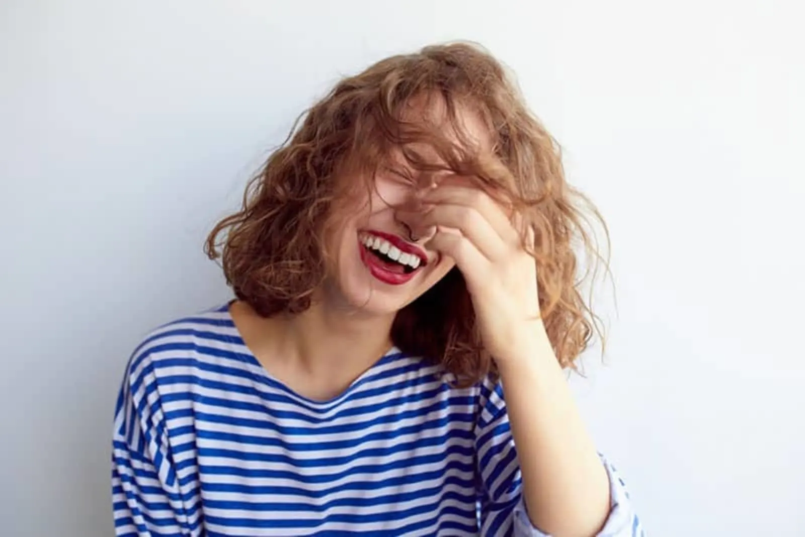 a woman with shorter brown hair laughs