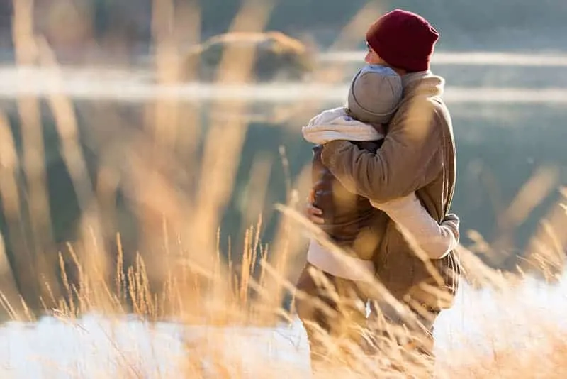 back view of lovely young couple hugging in winter
