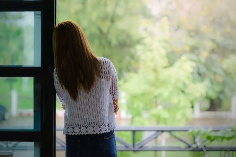 back view of woman leaning on door