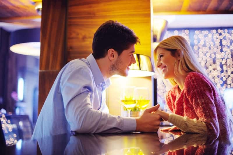 couple looking each other while holding hands in cafe
